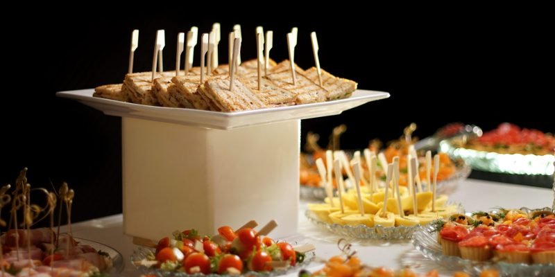 Delicious dishes on the table in the restaurant. Serving table. Black background, point light.